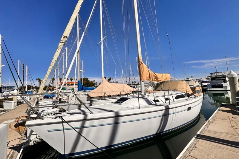 Slide: The Image of 1995 Catalina 36 MkII sailboat docked at marina under clear blue sky. - 1