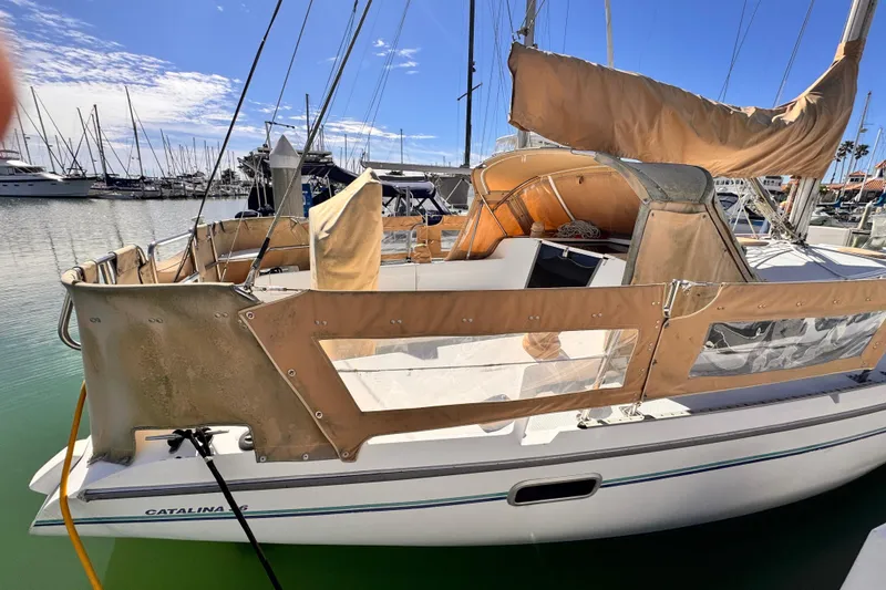 Slide: The Image of 1995 Catalina 36 MkII sailboat docked in a marina, featuring tan canvas covers. - 15