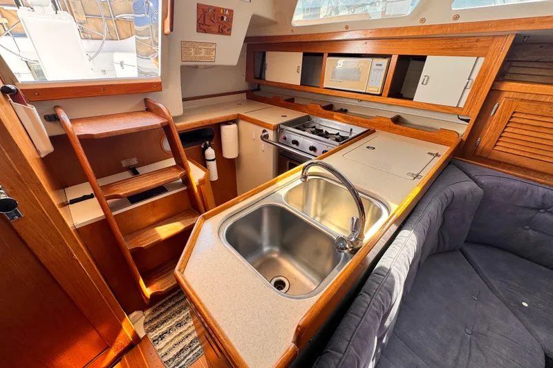 Slide: The Image of Interior of a 1995 Catalina 36 MkII sailboat kitchen with sink, stove, and seating area. - 6