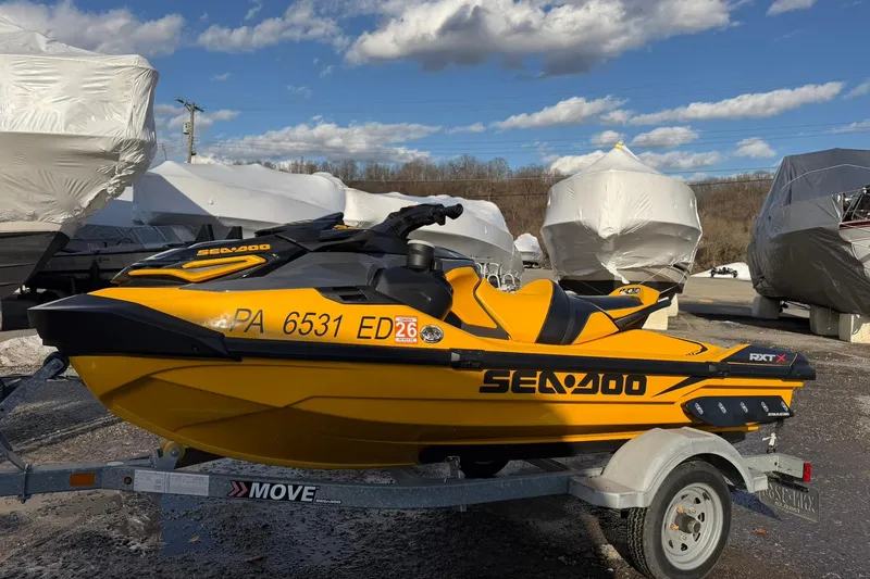 Slide: The Image of 2023 Sea-Doo RXT-X 300 jet ski on trailer, parked outdoors under blue sky. - 5