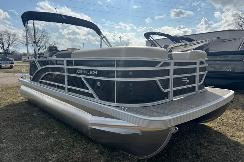 The Image of 2026 Bennington 20SL pontoon boat with sleek design, parked outdoors under a cloudy sky. - 0