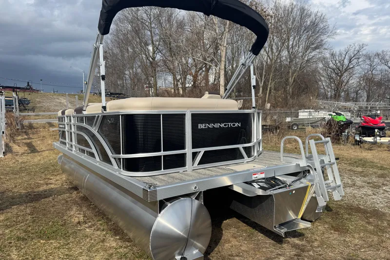 Slide: The Image of 2026 Bennington 20SL pontoon boat with canopy, parked on grassy area. - 10