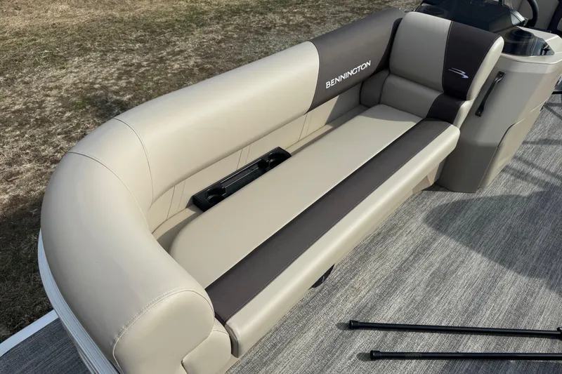 Slide: The Image of 2026 Bennington 20SL boat interior with beige and brown seating, cup holders, and sleek design. - 3