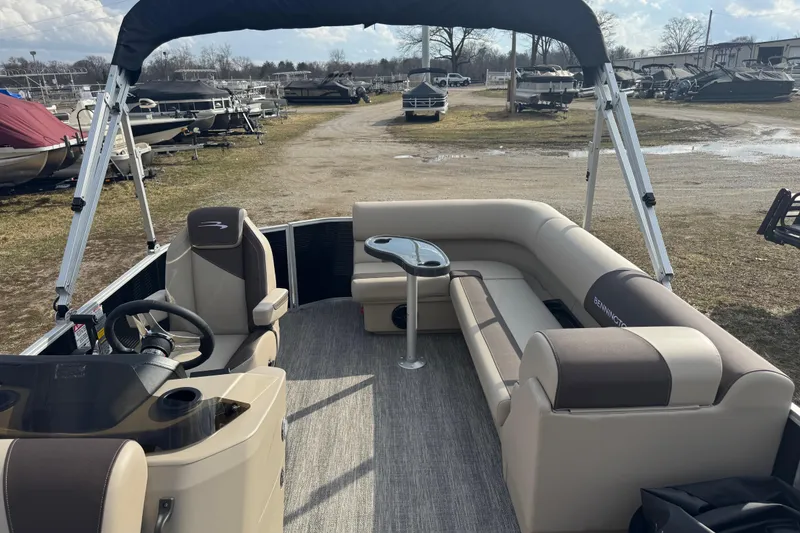Slide: The Image of 2026 Bennington 20SL pontoon boat with spacious seating and modern helm, parked outdoors. - 5