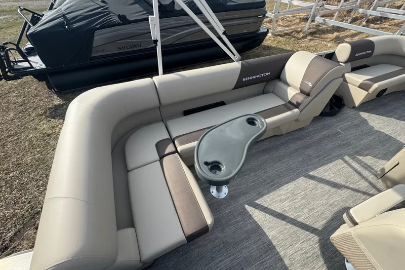 Slide: The Image of 2026 Bennington 20SL pontoon boat interior with beige seating and a central table. - 9