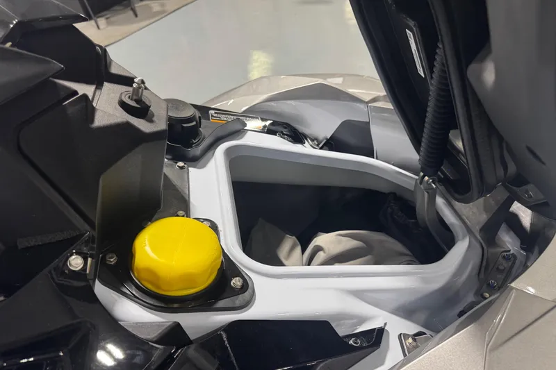 Slide: The Image of 2026 Kawasaki STX160LX storage compartment with yellow cap, open for viewing. - 10
