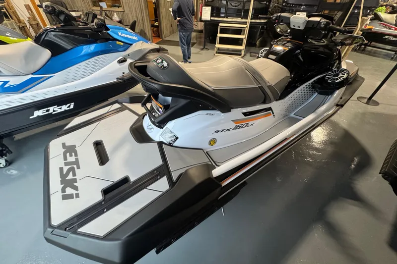 Slide: The Image of 2026 Kawasaki STX160LX jet ski in showroom, sleek design, gray and black color scheme. - 6