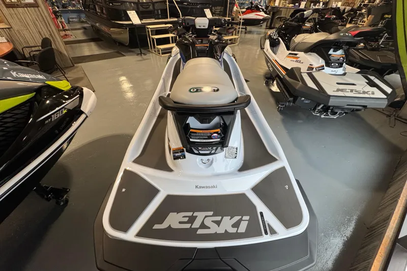 Slide: The Image of 2026 Kawasaki STX160X jet ski displayed in a showroom with other models. - 8