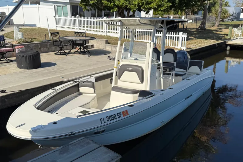 Slide: The Image of 2019 Stingray 236 CC boat on calm water under cloudy sky. - 0