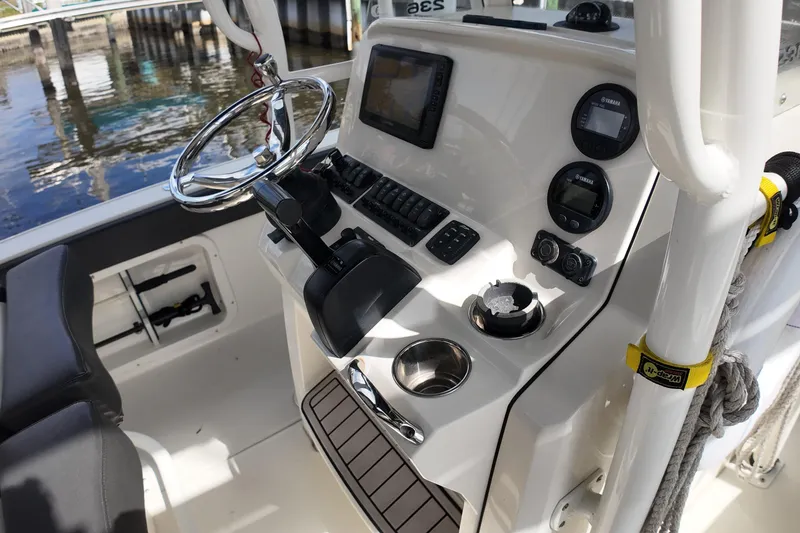 Slide: The Image of 2019 Stingray 236 CC boat console with steering wheel and navigation controls. - 16