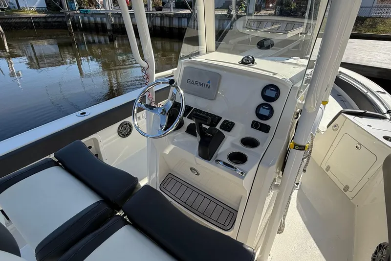 Slide: The Image of 2019 Stingray 236 CC boat cockpit with Garmin navigation system and sleek steering wheel. - 23
