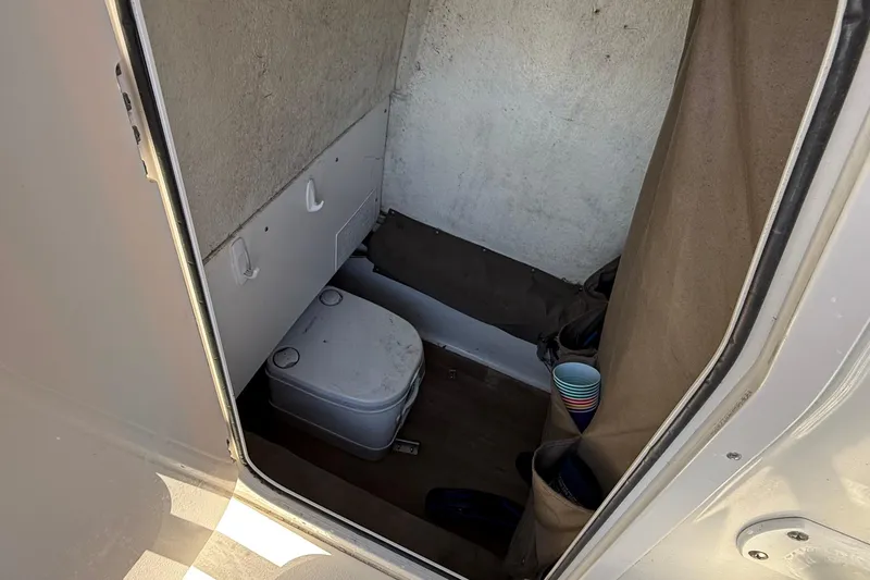 Slide: The Image of Interior of 2019 Stingray 236 CC boat with compact toilet and storage. - 24