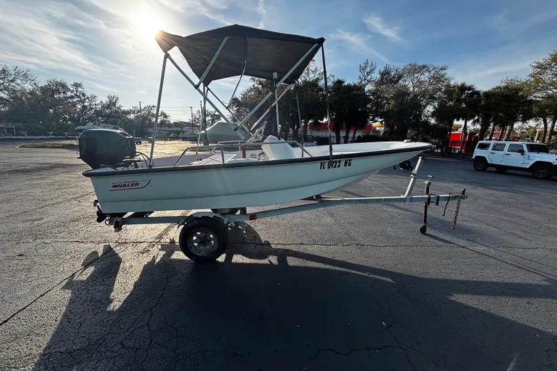 Slide: The Image of 2000 Boston Whaler Sport 13 boat on trailer, parked in sunny outdoor setting. - 2