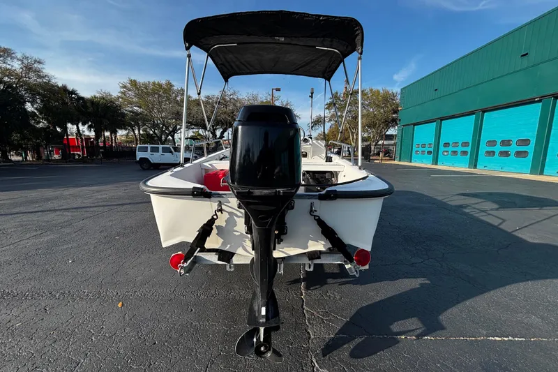 Slide: The Image of 2000 Boston Whaler Sport 13 boat with outboard motor, parked outdoors. - 3