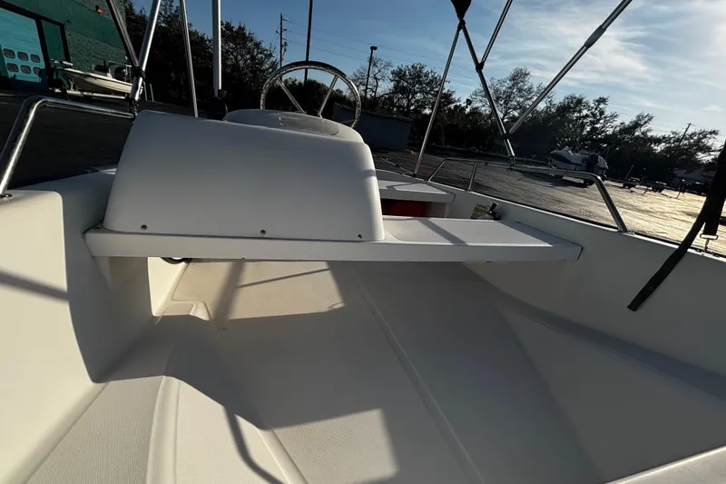 Slide: The Image of 2000 Boston Whaler Sport 13 boat interior with steering wheel and seating area. - 5