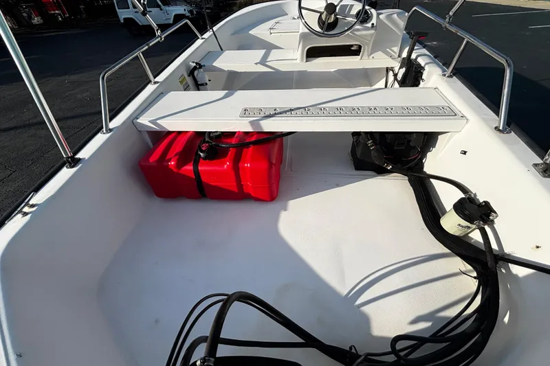 Slide: The Image of 2000 Boston Whaler Sport 13 boat interior with red fuel tank and steering console. - 8