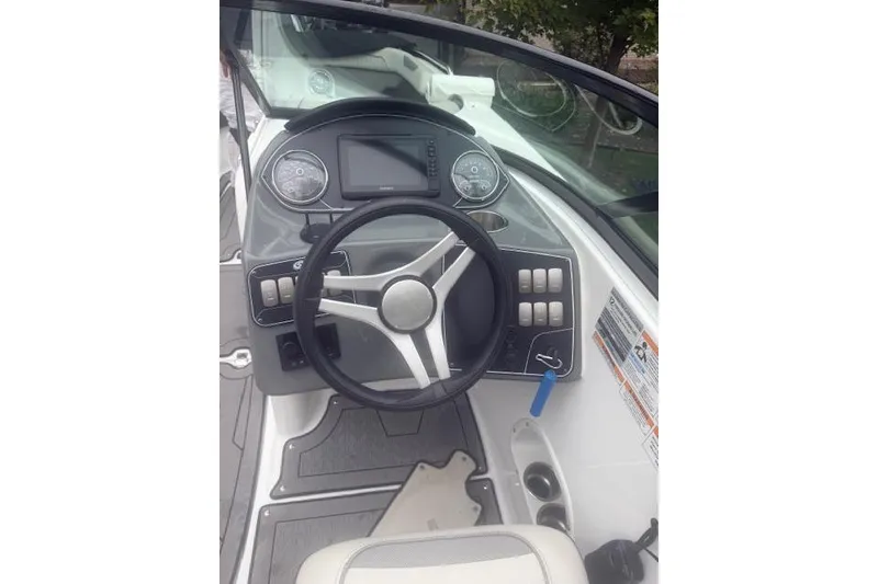 Slide: The Image of 2021 Hurricane SunDeck 2400 OB boat dashboard with steering wheel and controls. - 10