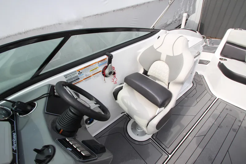 Slide: The Image of 2021 Hurricane SunDeck 2400 OB boat cockpit with steering wheel and captain's chair. - 19