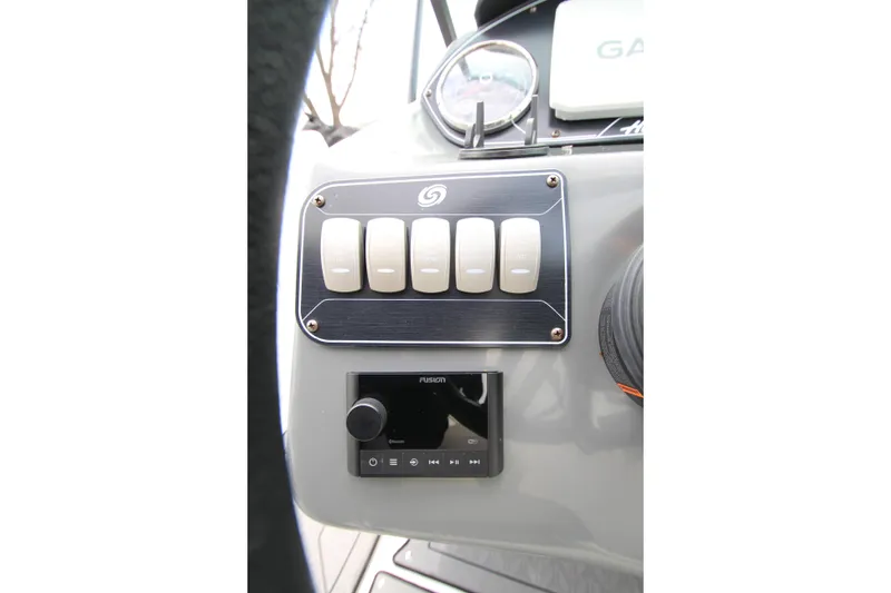 Slide: The Image of Control panel of 2021 Hurricane SunDeck 2400 OB boat with switches and audio system. - 25