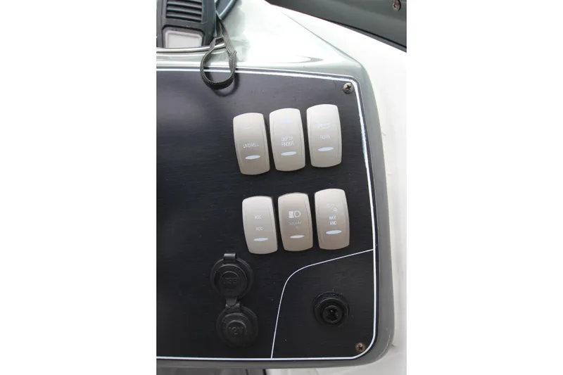 Slide: The Image of Control panel of 2021 Hurricane SunDeck 2400 OB boat with labeled switches. - 26