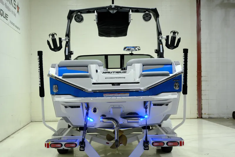 Slide: The Image of Rear view of a 2023 Nautique G23 boat indoors. - 8