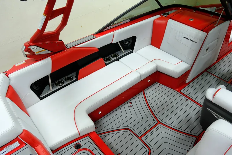 Slide: The Image of Interior of a 2018 Nautique 210 boat with red and white seating. - 10
