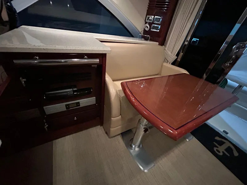 Slide: The Image of Interior of 2010 Sea Ray 610 Sundancer with wooden table and leather sofa. - 17
