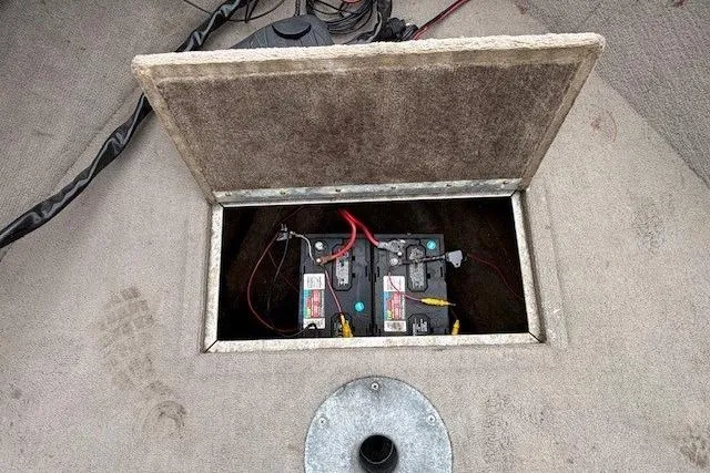 Slide: The Image of Battery compartment of a 2003 Monark King 190 boat, showing two connected batteries. - 12