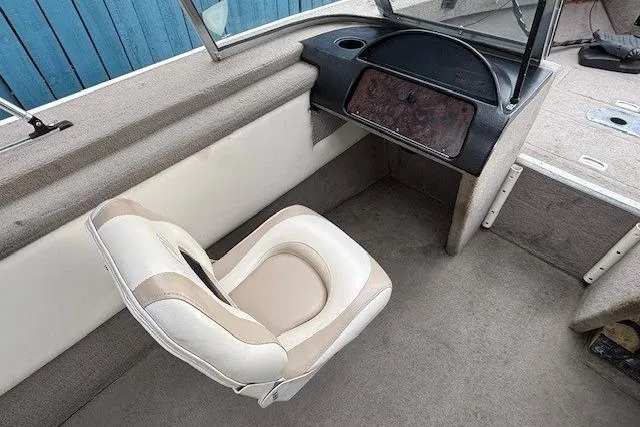 Slide: The Image of 2003 Monark King 190 boat interior with beige seating and dashboard. - 16
