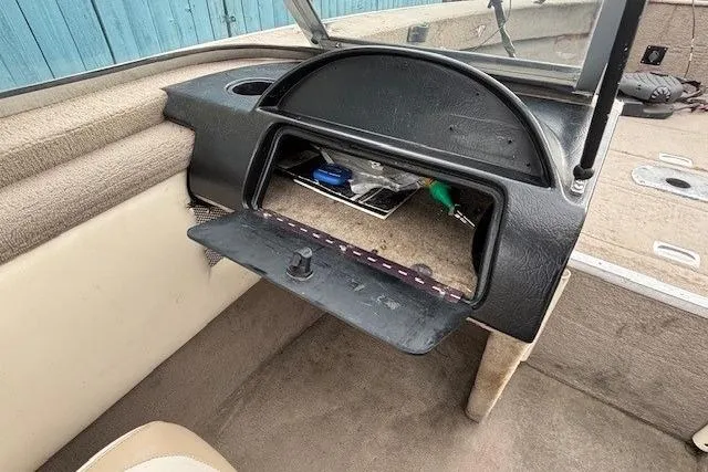 Slide: The Image of 2003 Monark King 190 boat interior with open glove compartment and beige upholstery. - 22