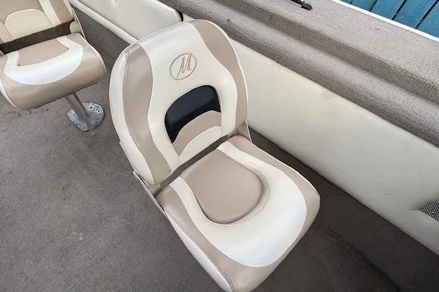 Slide: The Image of Boat seat from a 2003 Monark King 190, featuring beige and white upholstery. - 23