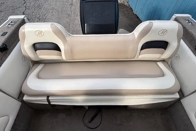 Slide: The Image of Rear seating of a 2003 Monark King 190 boat, featuring beige and white upholstery. - 30