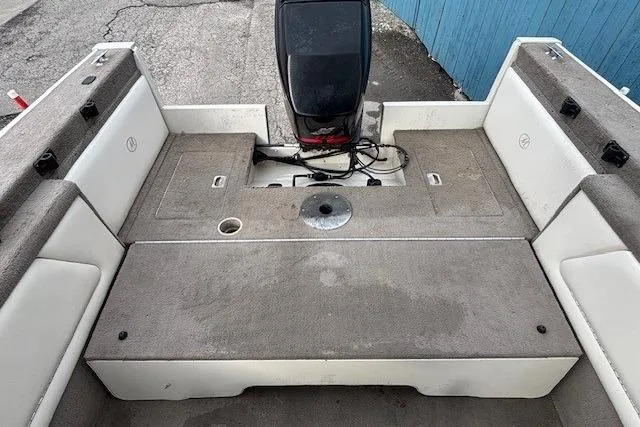 Slide: The Image of 2003 Monark King 190 boat interior with motor, featuring spacious seating and storage. - 31