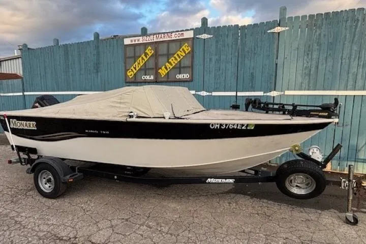 Slide: The Image of 2003 Monark King 190 boat on trailer, covered, parked outside Sizzle Marine dealership. - 35
