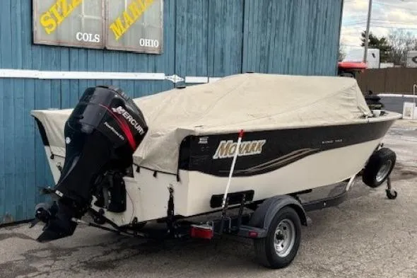 Slide: The Image of 2003 Monark King 190 boat with cover and Mercury outboard motor, parked on trailer. - 36