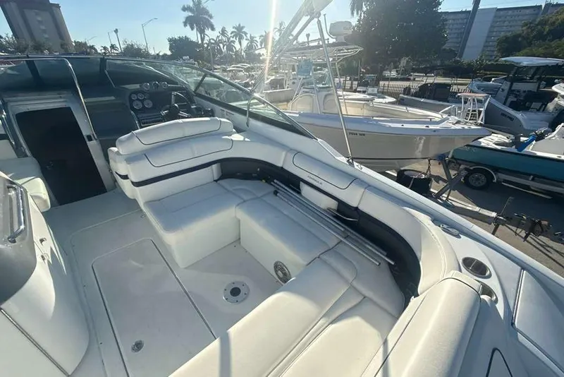 Slide: The Image of 2014 Formula 290 Sun Sport boat interior with white seating and dashboard, docked at marina. - 18