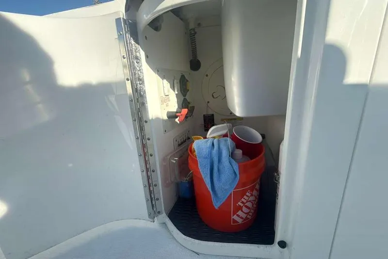 Slide: The Image of 2014 Formula 290 Sun Sport storage compartment with cleaning supplies and bucket. - 23