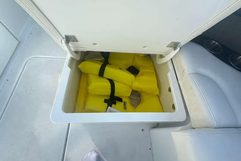 Slide: The Image of Storage compartment with yellow life jackets on a 2014 Formula 290 Sun Sport boat. - 32