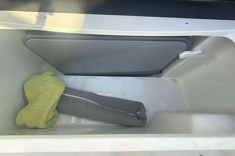 Slide: The Image of Storage compartment in a 2014 Formula 290 Sun Sport boat with towel and cushion. - 33