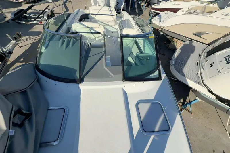 Slide: The Image of 2014 Formula 290 Sun Sport boat with open deck and windshield, docked among other boats. - 48