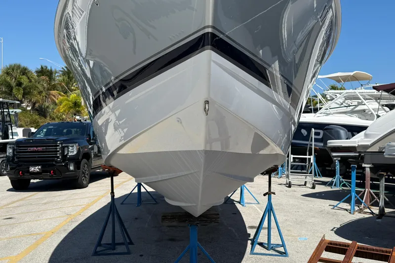 Slide: The Image of 2014 Formula 290 Sun Sport boat on stands in a marina, with a truck nearby. - 5