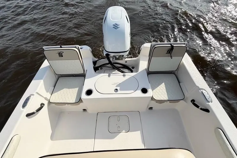 Slide: The Image of 2022 Carolina Skiff 19 LS boat interior with seating and motor on water. - 16
