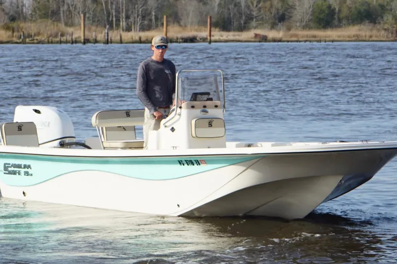 Slide: The Image of 2022 Carolina Skiff 19 LS boat on water with person at helm. - 8