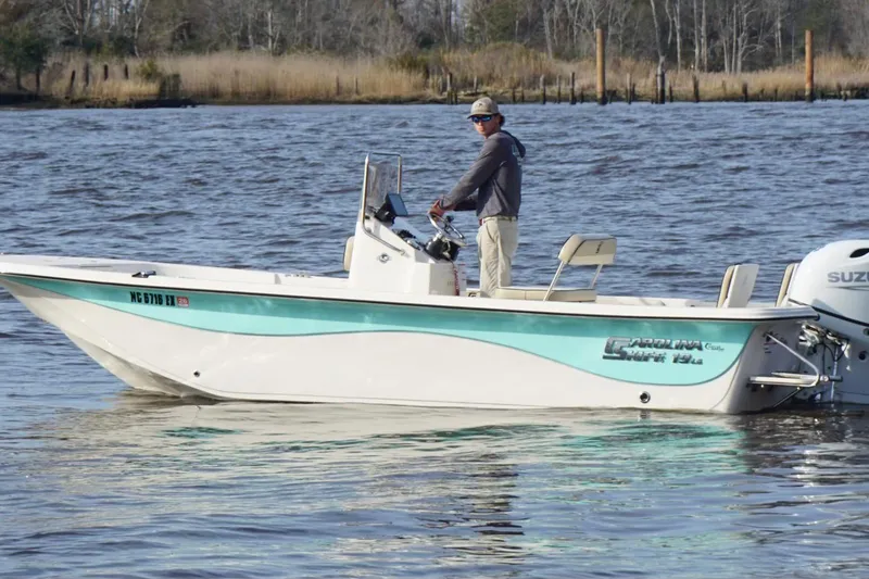 Slide: The Image of 2022 Carolina Skiff 19 LS boat on water with person steering. - 9