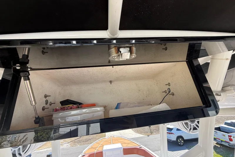 Slide: The Image of Open storage compartment on a 2005 Renegade 29CC boat, showing interior contents. - 14