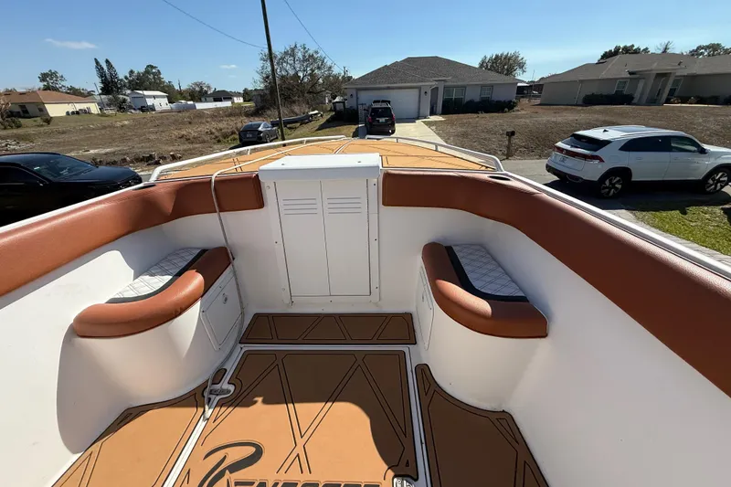 Slide: The Image of 2005 Renegade 29CC boat interior with brown seating and storage compartments. - 20