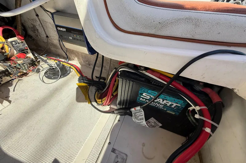 Slide: The Image of 2005 Renegade 29CC boat battery compartment with wiring and charger setup. - 28