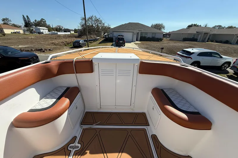 Slide: The Image of 2005 Renegade 29CC boat interior with brown seating and white storage compartments. - 29