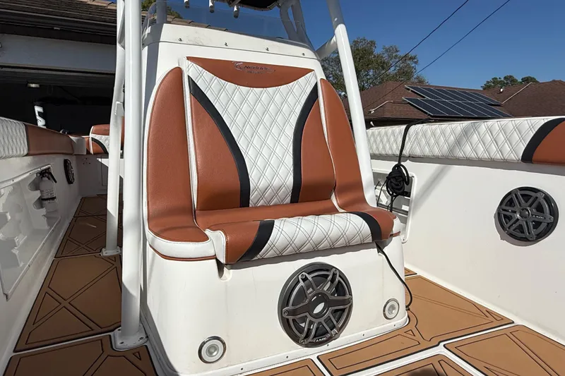 Slide: The Image of 2005 Renegade 29CC boat interior with brown and white seating, speaker, and deck details. - 34