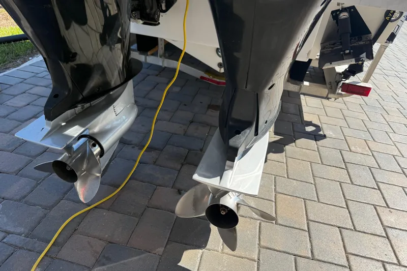 Slide: The Image of Twin outboard motors on a 2005 Renegade 29CC boat, parked on a paved surface. - 42